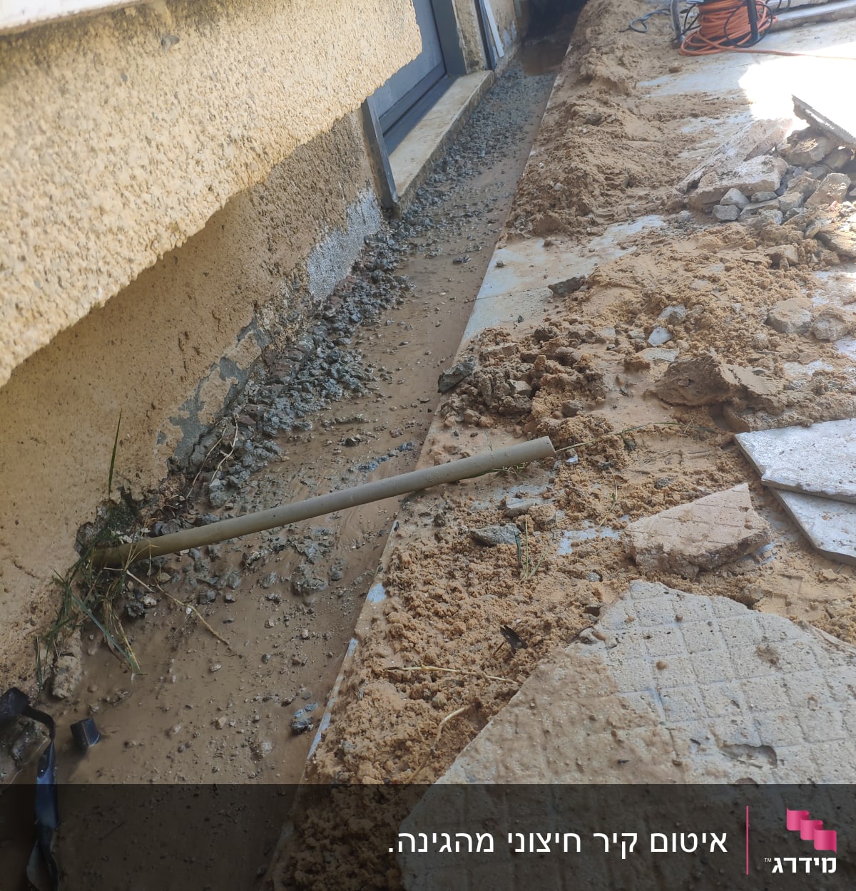 חפירה ליד קיר עם חצץ ואדמה